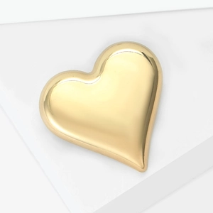 Detailed close-up of a polished gold heart brooch on a clean white geometric surface