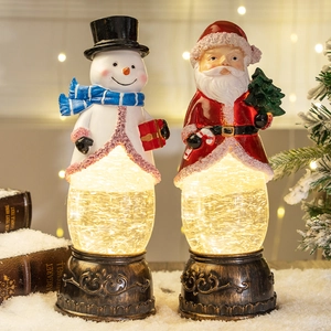 Illuminated Christmas snow globe lanterns with Santa and snowman on vintage bronze bases