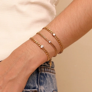 Detailed view of three-piece 18K gold-plated Cuban chain bracelets with zircon on wrist