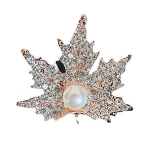 Elegant rose gold maple leaf brooch with sparkling crystals and a large white pearl center