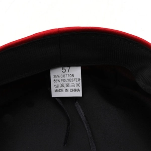 Macro shot of red beret hat interior tag showing 35% cotton material and size 57 label
