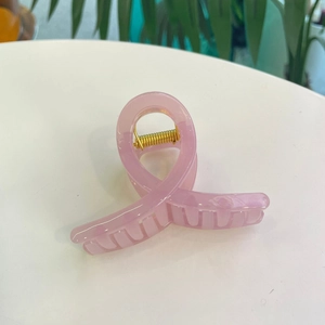 Vue détaillée d'une pince à cheveux rose transparente en acrylique avec ressort doré