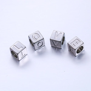 Vue macro de perles alphabet carrées de 7mm en acier inoxydable épelant LOVE pour bijoux
