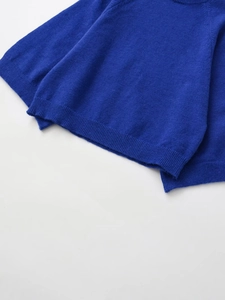 Détail de l'ourlet et du poignet côtelés sur un pull en maille bleu roi à col montant
