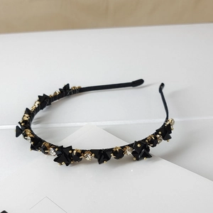 Macro detail of luxury headband featuring black crystals and clear rhinestones