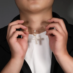 Close-up of a gold-plated crown cross pendant necklace with sparkling cubic zirconia