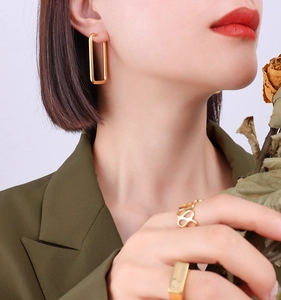 Minimalist 18k gold earrings and infinity ring set worn by model with modern aesthetic