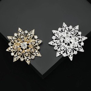 Elegant gold and silver rhinestone sunflower brooches on a black geometric display stand
