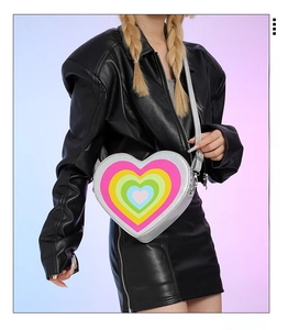 Detail of silver heart-shaped crossbody bag with colorful layered heart pattern