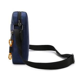 Vertical deep blue crossbody bag for men with black shoulder strap and side view detail