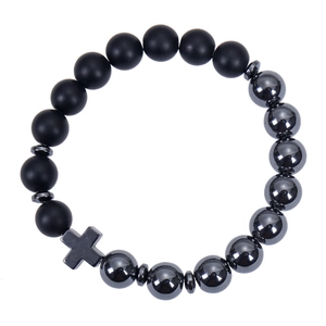 Macro shot of matte black stone and metallic beads with a small cross charm