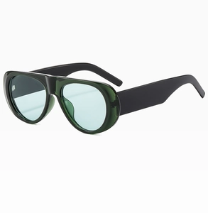 Detail view of oversized jelly green sunglasses with wide temples and blue tinted lenses