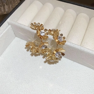 Detail of vintage gold flower C-shaped earrings with sparkling crystal inlay