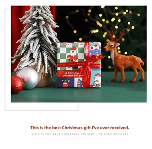 Close-up of a Christmas gift box with Santa illustrations and festive red ribbon decor