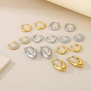 Collection of geometric U-shaped gold and silver earrings with polished finish and stones