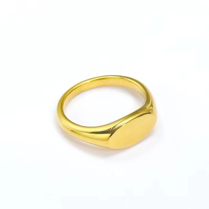 Macro detail of a polished gold-plated stainless steel oval signet ring with a smooth finish