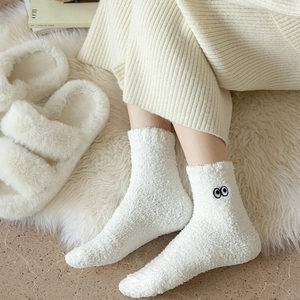Cozy white coral fleece warm socks with cute eye embroidery in a home setting