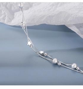 Macro shot of silver double-layered star bracelet with polished and frosted beads