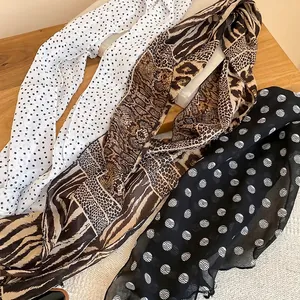 Elegant polka dot and animal print fabric scarf necklaces displayed on a wooden surface
