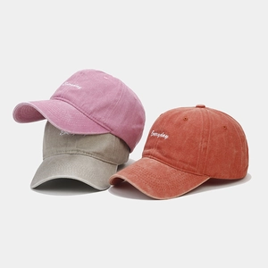 Detailed embroidery of 'Everyday' on washed cotton baseball caps in three vintage colors