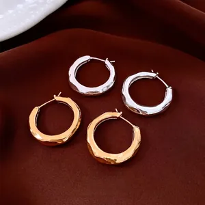 Minimalist gold and silver pleated hoop earrings with hammered texture on silk fabric