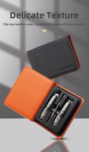Close-up of a three-piece manicure set in a textured black and orange leather flip case