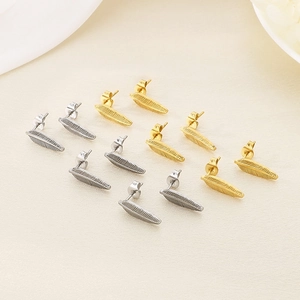 Detailed close-up of creative feather-shaped stud earrings in gold and silver metal finishes
