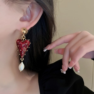 Vue détaillée d'une boucle d'oreille cœur rouge vintage avec perle baroque