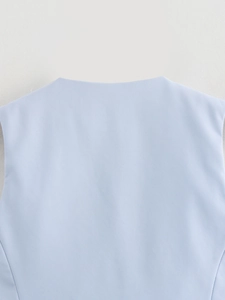 Gros plan sur la texture du tissu sergé bleu clair et le détail du col d'un gilet cintré