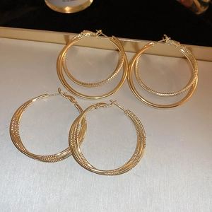 Boucles d'oreilles créoles dorées multicouches avec finitions polies et tressées