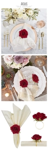 Close-up of red velvet rose napkin ring with a polished gold metal band for wedding decor