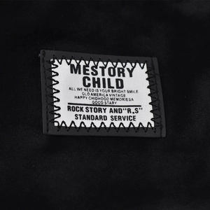 Detailed macro view of retro patch with embroidery on soft black knit chenille beanie
