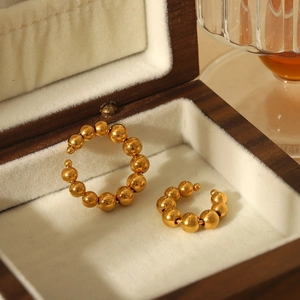 Vue détaillée de boucles d'oreilles dorées perlées dans un écrin en velours luxe