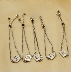 Detail of adjustable stainless steel alphabet charm bracelets from letters A to E