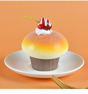 Macro shot of faux blueberry cherry cupcake fridge magnet with cream on a plate