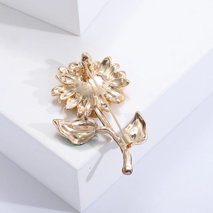 Detail view of the golden sunflower brooch back showing the secure safety pin fastener