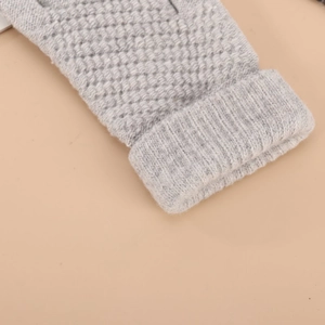 Close-up of grey knitted winter glove showing detailed ribbed and diamond weave patterns