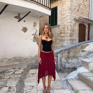 Lace-trim camisole and burgundy knit skirt set styled on a cobblestone street