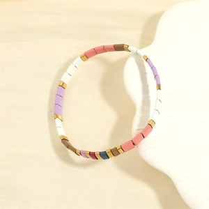 Macro detail of Tila bead bracelet with macaron enamel tiles and golden spacers