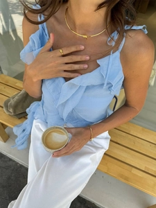 Minimalist gold jewelry set with knot necklace, ring, and bracelet on casual model