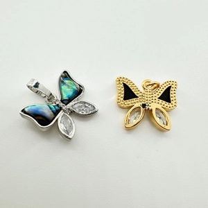 Détail de breloques papillon plaquées or 18K avec nacre, émail et zircons cubiques