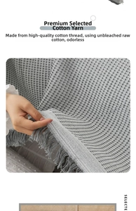 Detail of grey fringed sofa throw made from soft unbleached eco-friendly cotton yarn
