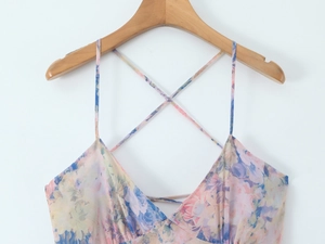 Detail of the V-neckline and delicate criss-cross straps on a floral chiffon maxi dress