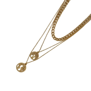 Layered gold necklace featuring hollow world map and tree of life pendants in a stackable style