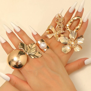 Ensemble de bagues géométriques dorées avec fleurs en métal et perles sur main