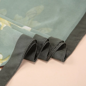 Close-up of elegant floral silk scarf showing satin texture and contrast border details