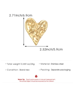 Vue macro d'une broche coeur irrégulière dorée en acier inoxydable avec dimensions
