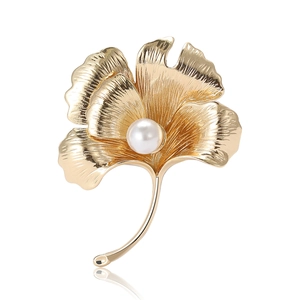 Elegant gold ginkgo leaf brooch with white pearl inlay and refined metal texture