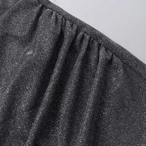 Macro shot of dark shimmering fabric with glitter details and vertical pleated texture