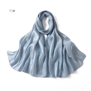 Detailed view of light blue satin scarf texture with silky sheen and soft draped edges